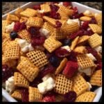 Nahaufnahme von einem Sch&uuml;ssel voller 4. Juli Snack Mix mit Cerealien, getrockneten Beeren und K&auml;se.