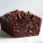 Nahaufnahme eines saftigen Chocolate Zucchini Bread mit Schokost&uuml;ckchen auf der Oberseite und im Inneren.