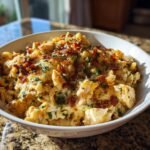 Nahaufnahme eines cremigen H&auml;hnchen-Speck-Ranch-Nudelauflaufs mit knusprigem Speck und Petersilie bestreut.