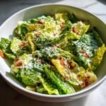 Sch&uuml;ssel mit frischem Caesar Salat, bedeckt mit cremigem Caesar Dressing, Parmesan und knusprigen Speckst&uuml;ckchen.