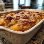 Ein frisch gebackener, einfacher Pfirsich Cobbler in einer Auflaufform, bestreut mit Zimt und Zucker.