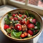 Nahaufnahme eines Sch&uuml;ssel mit erfrischendem Erdbeer-Spinat-Salat, garniert mit Waln&uuml;ssen und Feta.