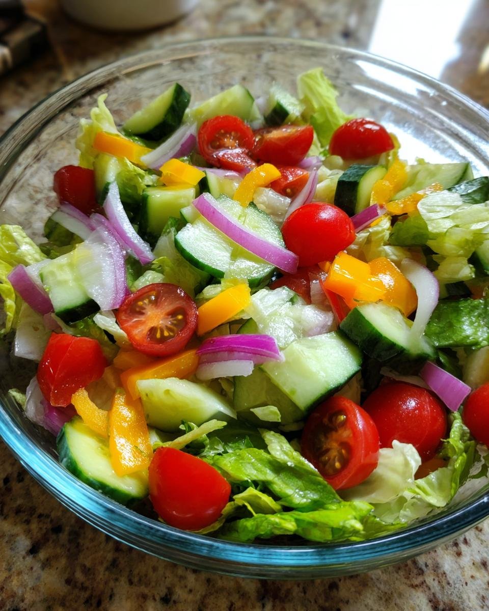 Nahaufnahme eines Sch&uuml;ssel mit frischem und knackigem Gartensalat-Mix mit Tomaten, Gurken, Paprika und Zwiebeln.