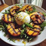 Herrlicher gegrillter Pfirsich Burrata Salat mit Rucola und Basilikum, betr&auml;ufelt mit Dressing.