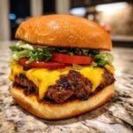 Ein saftiger K&auml;seburger mit geschmolzenem K&auml;se, Salat und Tomate, perfekt f&uuml;r Grill-Helden.