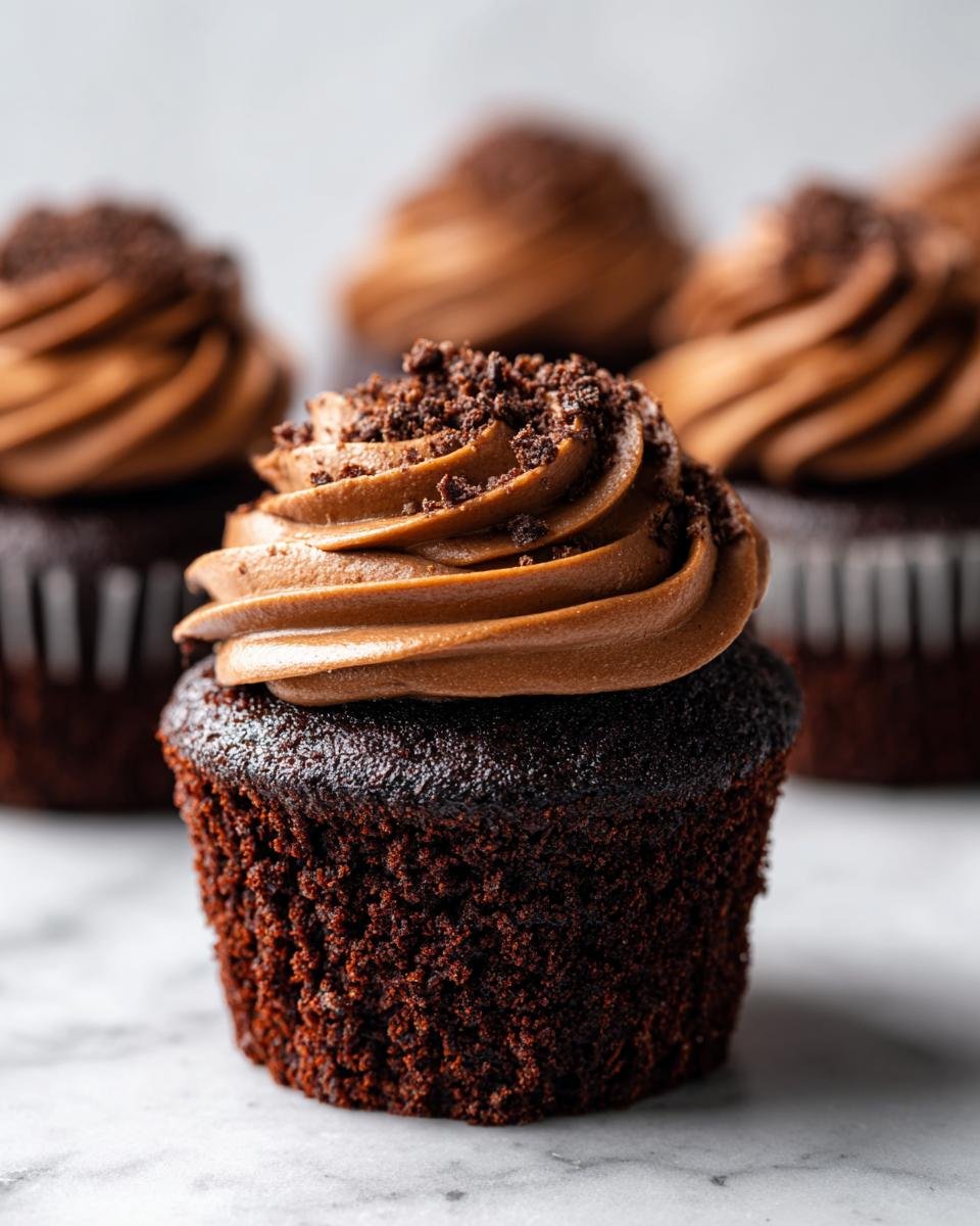 Nahaufnahme von Schokoladen-Kaffee-Creme-Cupcakes mit Schokoladenfrosting und Kr&uuml;meln.