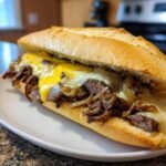 Ein k&ouml;stliches Philly Cheese Steak Sandwich mit geschmolzenem K&auml;se, zarten Rindfleischstreifen und karamellisierten Zwiebeln in einem Baguette.