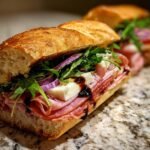 Nahaufnahme eines unglaublichen italienischen Sandwiches mit Aufschnitt, K&auml;se, Rucola und roten Zwiebeln.