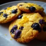 Nahaufnahme von unwiderstehlichen Zitronen-Blaubeer-Keksen mit frischen Blaubeeren und Zitronenschale.