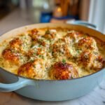 Nahaufnahme von unwiderstehlichem gebackenem Frischk&auml;se-H&auml;hnchen in einer blauen Auflaufform, garniert mit Petersilie und Parmesan.