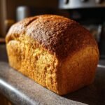 Ein frisch gebackenes, unwiderstehliches Vollkornbrot mit goldbrauner Kruste auf einer Arbeitsplatte.