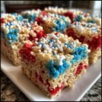 Nahaufnahme von roten, wei&szlig;en und blauen 4th Of July Rice Krispies Treats, bestreut mit Zuckerperlen.