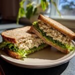Zwei H&auml;lften von Turkey Salad Sandwiches mit viel Salat und cremiger F&uuml;llung auf Vollkornbrot.