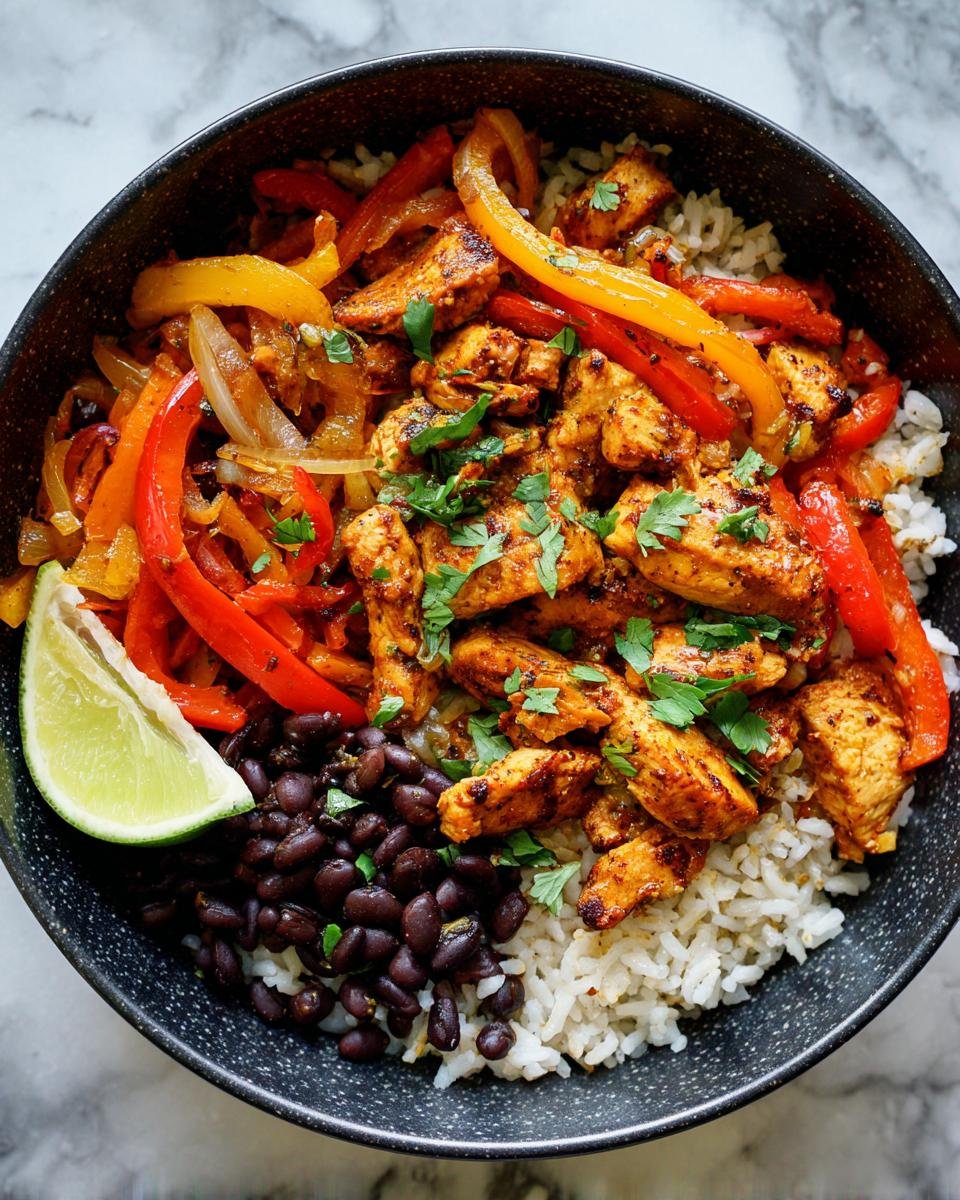 Eine Sch&uuml;ssel mit einer w&uuml;rzigen Flavorful Chicken Fajita Rice Bowl, garniert mit Koriander und Limettenspalte.