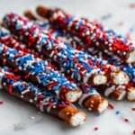 Close-up of Fourth of July Chocolate Pretzel Rods decorated with red, white, and blue sprinkles.