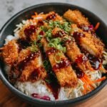 Nahaufnahme einer Japanese Katsu Bowl mit knusprigem Katsu, Reis, Salat und Sauce.