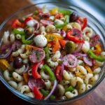 Nahaufnahme eines k&ouml;stlichen Antipasto Salats mit Pasta, Salami, Mozzarella-Kugeln, Oliven und Paprika.