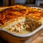 Nahaufnahme eines Auflaufs mit goldbrauner Bl&auml;tterteigkruste, gef&uuml;llt mit cremigem Fleisch und Gem&uuml;se (Leftover Turkey Pot Pie).
