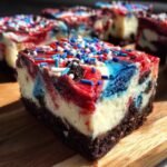 Ein St&uuml;ck No Bake Fireworks Oreo Cheesecake Bars mit roten, wei&szlig;en und blauen Wirbeln und Streuseln.