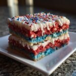 Gestapelte Rote Wei&szlig; Blaue Reiskuchen-Leckereien mit wei&szlig;em Zuckerguss und bunten Streuseln.