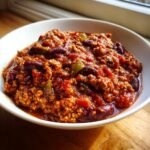 Nahaufnahme von cremigem Slow Cooker Turkey Chili mit Kidneybohnen und Paprika in einer wei&szlig;en Sch&uuml;ssel.