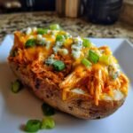 Ein ultimatives Buffalo Chicken Loaded Potatoes, &uuml;berbacken mit K&auml;se und Fr&uuml;hlingszwiebeln.