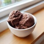 Nahaufnahme von zwei Kugeln dunklem Chocolate Espresso Ice Cream in einer wei&szlig;en Schale.
