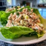 Nahaufnahme von Chopped Salmon Salad mit Sellerie und Petersilie, serviert in einem knackigen Salatblatt.