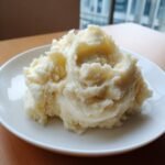 Ein gro&szlig;er Klecks cremiger Kartoffelp&uuml;ree auf einem wei&szlig;en Teller, ideal f&uuml;r Freezer Mashed Potatoes.
