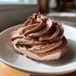 Nahaufnahme von Easy Whipped Chocolate Buttercream Frosting, aufgespritzte Schokoladencreme auf einem wei&szlig;en Teller.