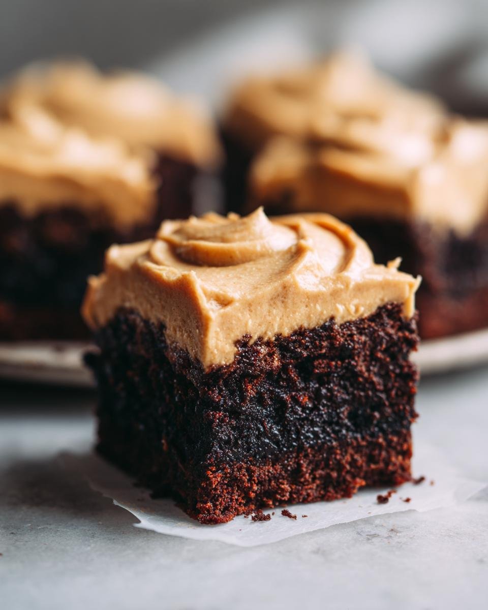 Nahaufnahme eines saftigen Fudge Brownies mit einer dicken Schicht Baileys Buttercreme.
