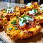 Nahaufnahme von knusprigen Kartoffelschalen, gef&uuml;llt mit K&auml;se, Speck und Sauerrahm.