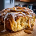 Nahaufnahme von saftigen Caramel Sweet Rolls, &uuml;bergossen mit Karamell- und wei&szlig;em Zuckerguss.
