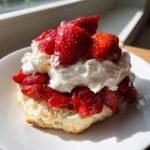 Nahaufnahme eines k&ouml;stlichen Strawberry Shortcakes mit viel Schlagsahne und gl&auml;nzenden, marinierten Erdbeeren.