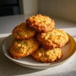 Stapel goldbrauner, knuspriger Kekse, die mit Cornflake Recipes zubereitet wurden, auf einem hellen Teller.