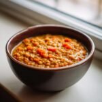 Eine dunkle Schale mit w&uuml;rzigem Linseneintopf und Karottenst&uuml;cken, ideal f&uuml;r Ramadan Recipes.