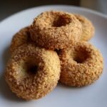 Nahaufnahme von mehreren ringf&ouml;rmigen Raw Sugar Thumbprint Cookies, die in braunem Zucker gew&auml;lzt sind.