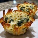 Zwei knusprige Spinat-Artischocken-Dip Parmesan Cups mit geschmolzenem K&auml;se und Spinatf&uuml;llung.