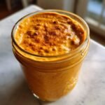 Cremige Sweet Potato Pie Overnight Oats mit Zimt bestreut in einem Einmachglas.