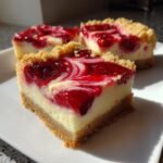 Nahaufnahme von drei saftigen Cherry Cheesecake Bars mit Kirschtopping auf einem wei&szlig;en Teller.
