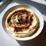Eine Sch&uuml;ssel cremiger Truffle Mashed Potatoes, garniert mit dunklem Tr&uuml;ffelpulver in einer Spiralform.