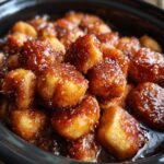 Nahaufnahme von saftigen St&uuml;cken Crockpot Monkey Bread, bedeckt mit einer gl&auml;nzenden Karamellsauce.