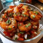 Nahaufnahme von Garnelen in einer w&uuml;rzigen, roten Sauce mit gehackten Zwiebeln und Koriander, Teil des Delicious Mexican Shrimp Cocktail Recipe.
