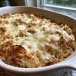 Nahaufnahme eines cremigen Auflaufs mit Orzo-Nudeln, H&auml;hnchenst&uuml;cken und geschmolzenem K&auml;se, dem 30 Minute French Onion Chicken Orzo Casserole.