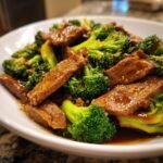 Nahaufnahme von zartem Panda Express Beef And Broccoli mit gl&auml;nzender Sauce in einer wei&szlig;en Sch&uuml;ssel.