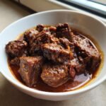 Nahaufnahme von zartem, geschmortem Fleisch in einer dunklen, w&uuml;rzigen So&szlig;e: Paula Deens Goulash.