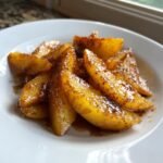 Nahaufnahme von in Zimt und Zucker gebratenen Apfelspalten auf einem wei&szlig;en Teller &ndash; Quick Delicious Fried Apples Recipe.