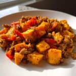 Nahaufnahme eines Quick Turkey Sweet Potato Skillet mit gew&uuml;rfelten S&uuml;&szlig;kartoffeln und Hackfleisch auf einem wei&szlig;en Teller.