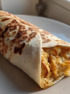 Nahaufnahme eines gebr&auml;unten Wraps, gef&uuml;llt mit cremigem H&auml;hnchen und K&auml;se &ndash; Quick And Cheesy Garlic Chicken Wraps.