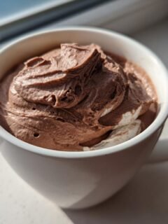 Nahaufnahme eines cremigen, schokoladigen Wendys Frosty Rezept in einer wei&szlig;en Tasse, beleuchtet von Sonnenlicht.